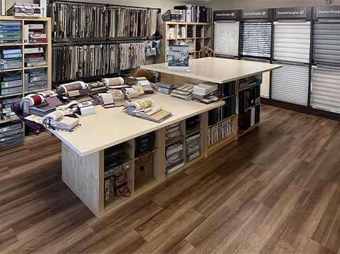 Store interior showcasing several different types of window coverings and fabric samples